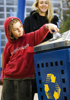 A boy recycles a plastic bottle